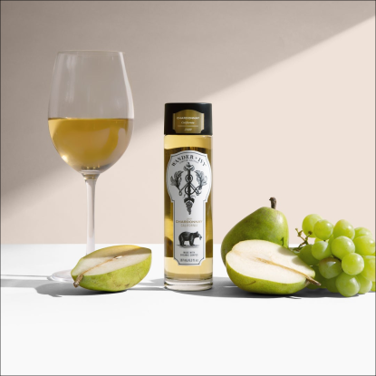 single-serve bottle of white wine on a table with grapes and pears